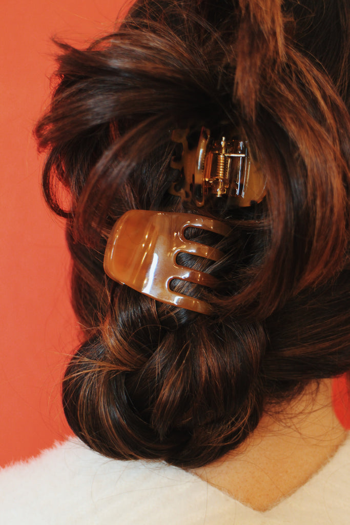 Models hair swept up with mini clips in cognac and tortoise